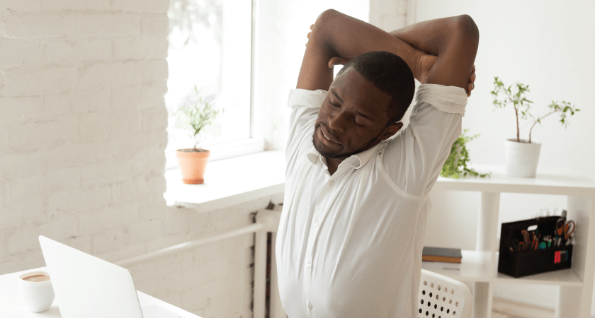 Man stretching arms while sitting in a chair