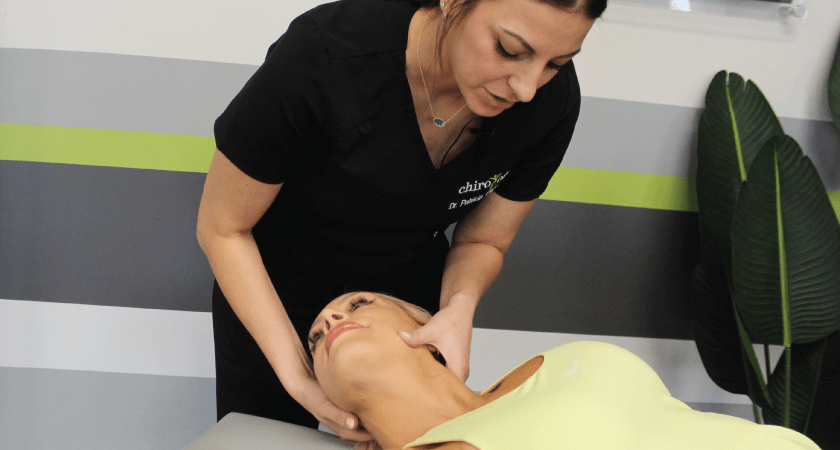 Woman on table being adjusted by chiropractor